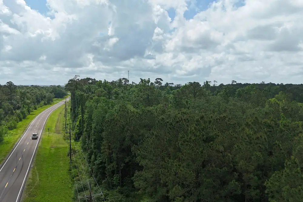 The road on FM 562 running toward Tract 2 under a cloudy sky, Anahuac, Texas.