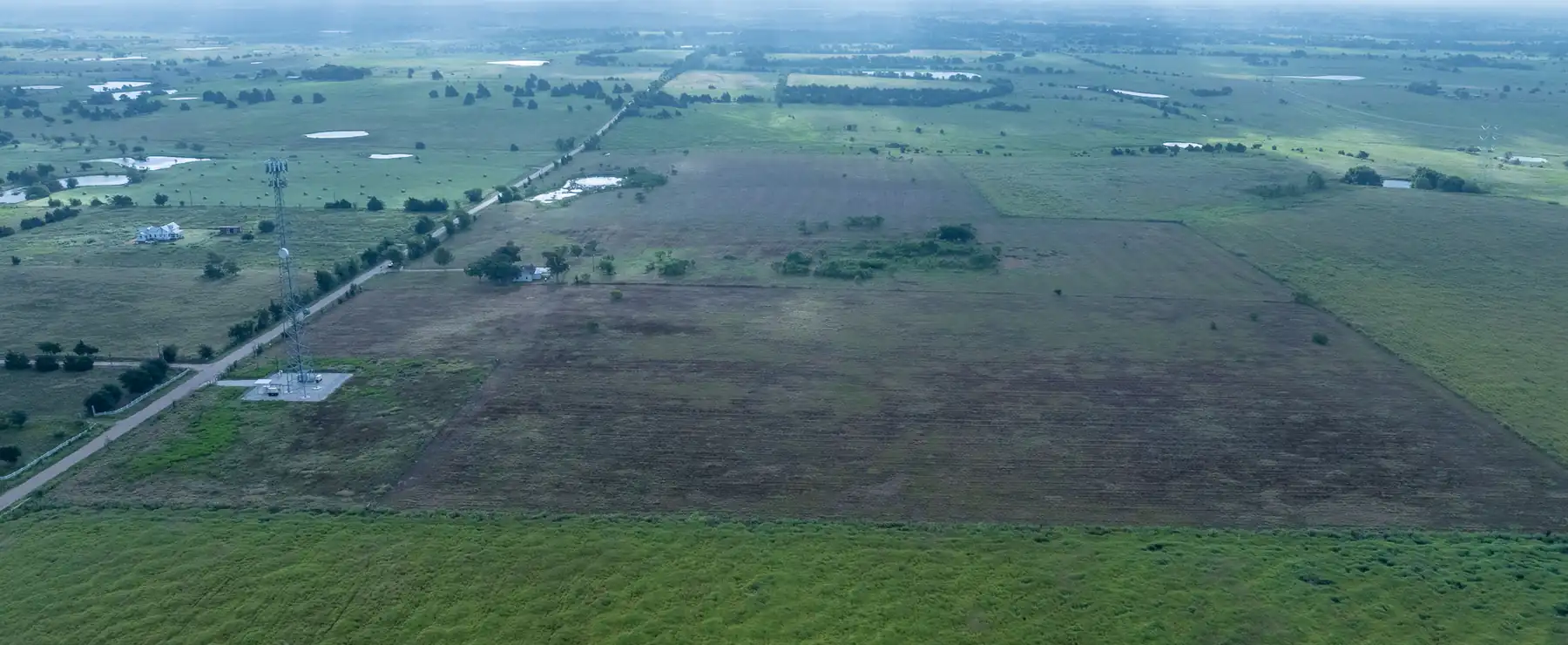 Flat open field under a moody sky near La Grange, Texas.